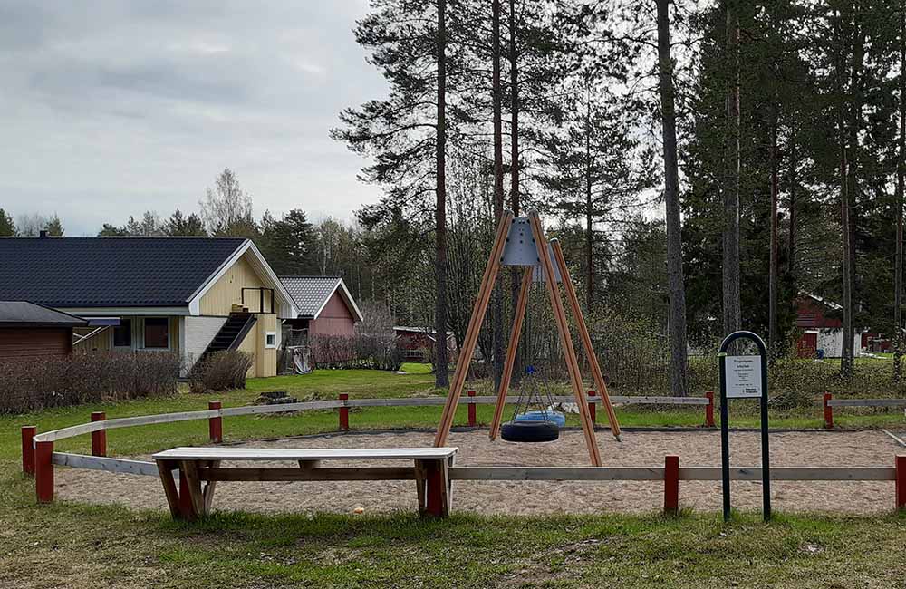 Gungor med lågt staket runt om och sittbänk i närheten